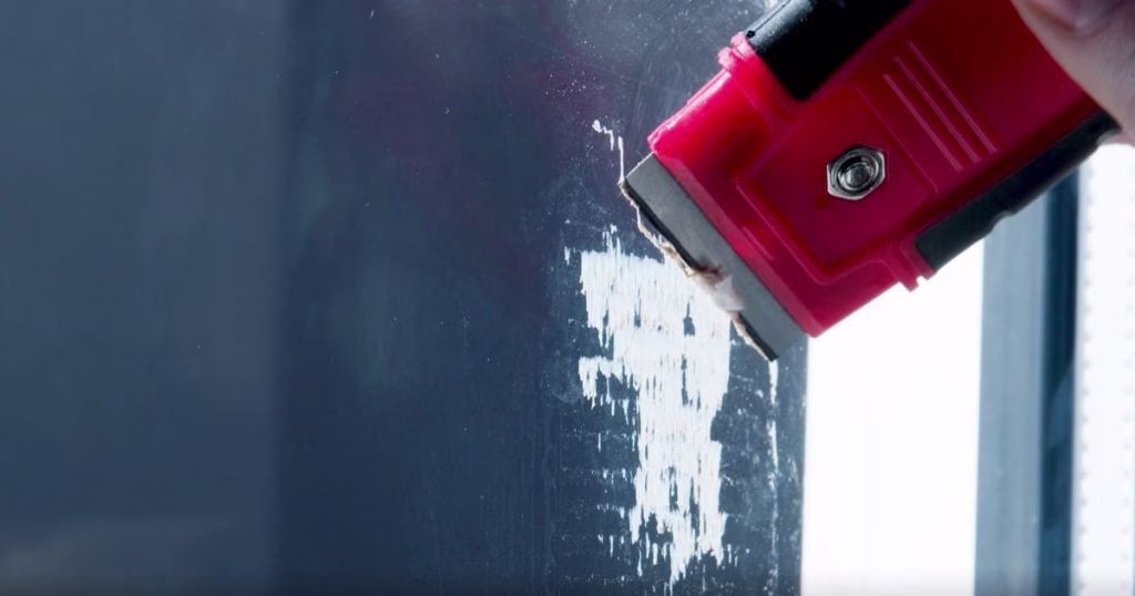 Removing duct tape adhesive residue from glass with blade